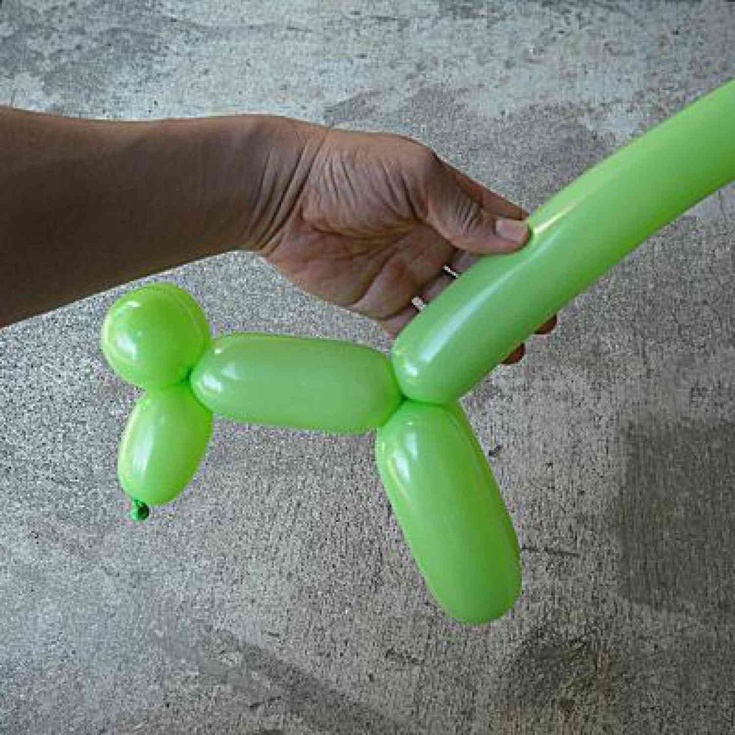 Person holding twisted green balloon