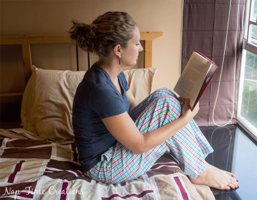 一个女人坐在她的床上看书