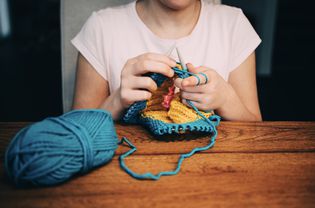 Girl knitting a hat in the round