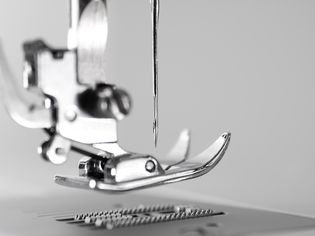 缝纫机压脚和针的特写。