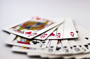 扑克牌呈扇形分布:黑桃、梅花和方块在白色背景上呈扇形分布。赌博，扑克，赢，输，机会，赌博，钱，红，黑，杰克，皇后，国王