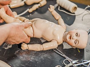 A doll being worked on in a repair shop