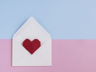 情人节的信:信封折纸心形准备爱在彩色的背景信息。正上方和复制空间
