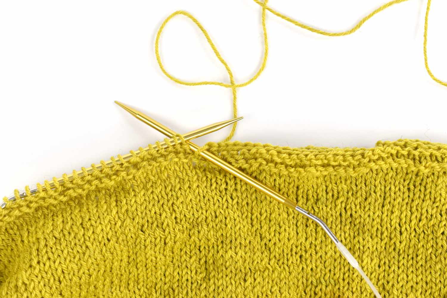 Two knitting needles in chartreuse yarn