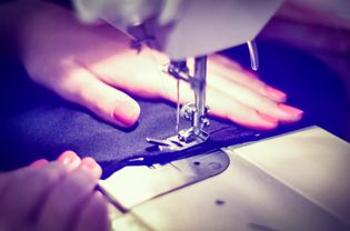 裁剪图像的妇女缝制织物上的缝纫机