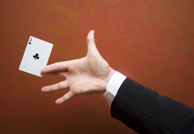 Close-up of magician performing trick with ace card