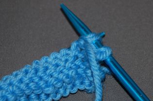 Purl in the front and back of a stitch while knitting