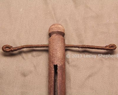 手臂嵌在一个木制的衣服别针里，用来做衣夹娃娃。