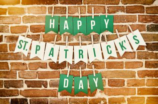 Happy St. Patrick's Day banner lettering on brick wall.