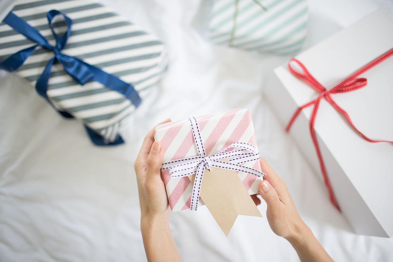 女牵手礼盒与礼物标签在床上