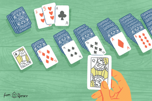 A hand playing solitaire