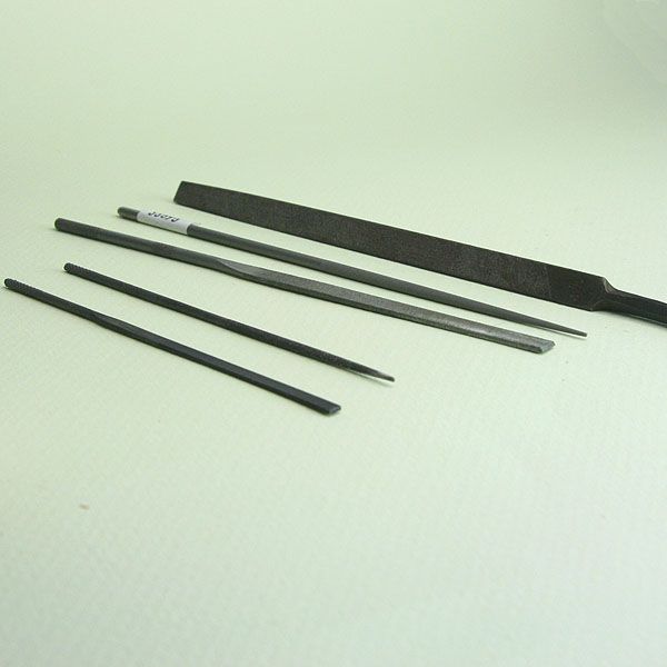 Assortment of miniature metal and wood files for craft work.