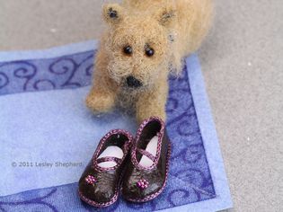 Doll shoes shown with a miniature felted Norwich terrier.