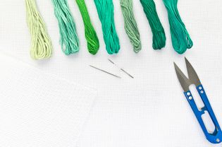 平铺顶视图与刺绣帆布，针，线在绿色的颜色