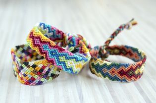 Group of simple handmade homemade natural woven bracelets of friendship on wooden background