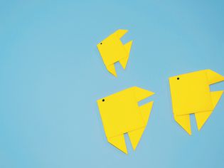 High Angle View Of Yellow Paper Fish On Blue Background