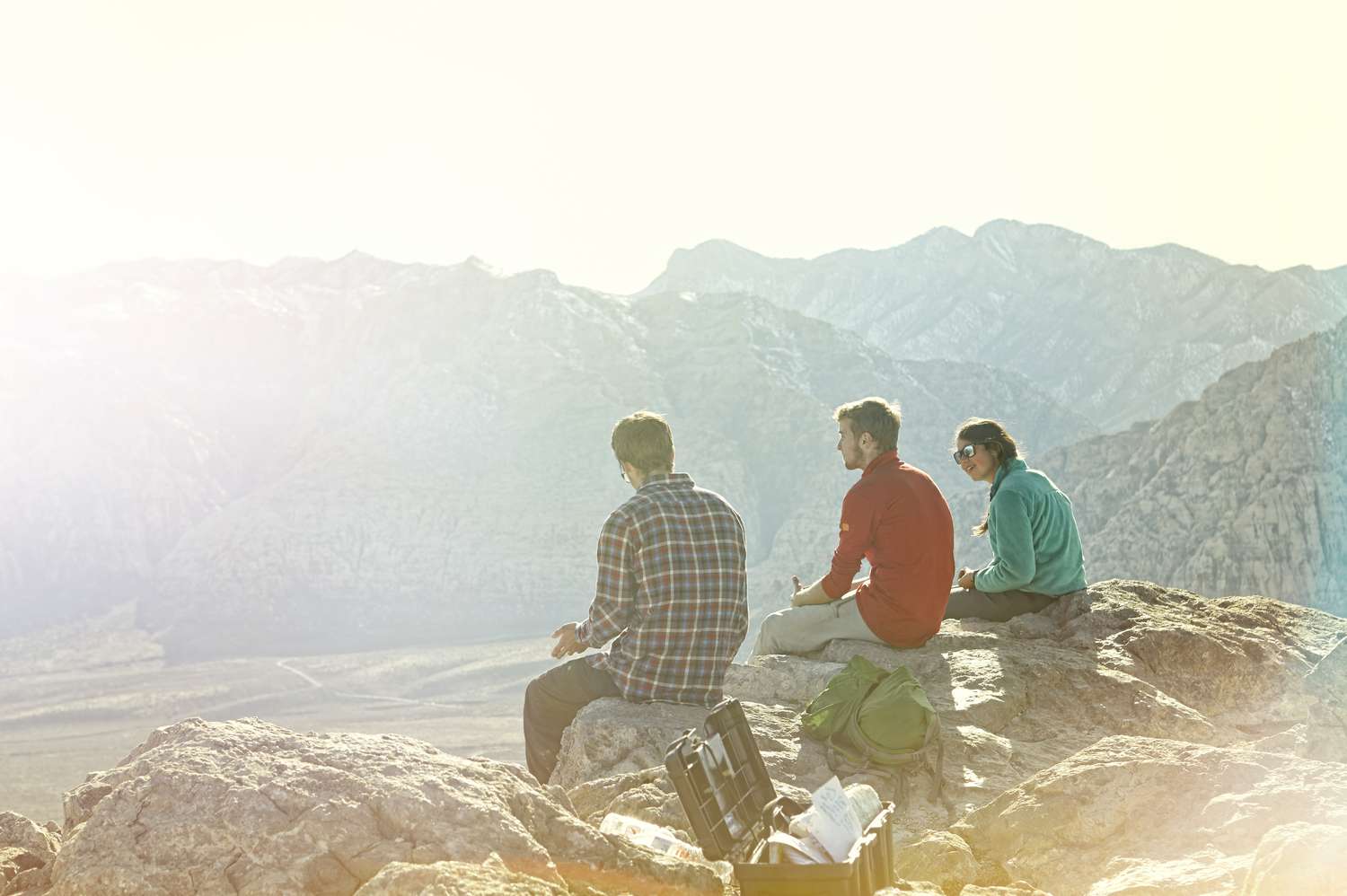三个朋友坐在山顶