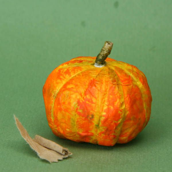 A roll of brown kraft paper makes a stem on the top of a dolls house scale paper mache pumpkin.