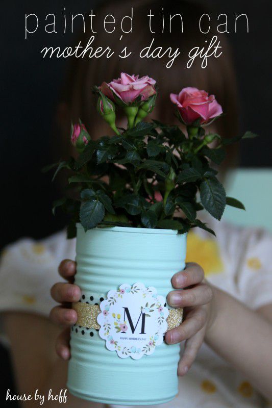 画锡罐与丝带和M象征手里拿着玫瑰花