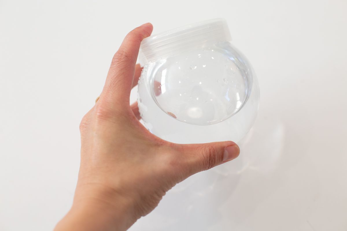A hand holding the snow globe with glycerin