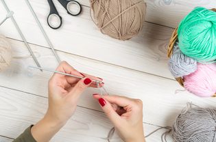 针织。手钩针。女手织钩。前视图。女人手里织毛衣