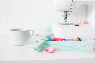 Cup And Thread Spools On Sewing Machine