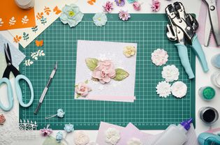 Multi-colored paper crafts on the cutting mat and scrapbooking tools