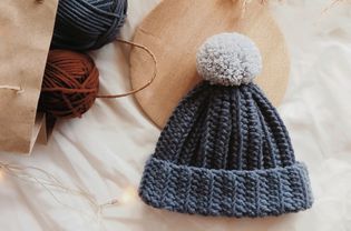 a crochet hat with a pom