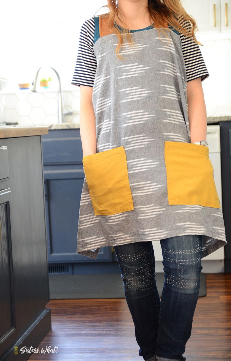 一个女人穿着一个灰色和黄色的围裙在厨房里