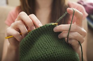 USA, Utah, Lehi, Young woman knitting woolly hat