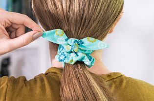 Light blue patterned hair scrunchie wrapped around low ponytail