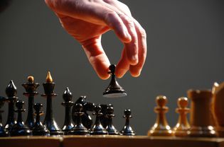 Hand moving the pieces of a chess board, close-up