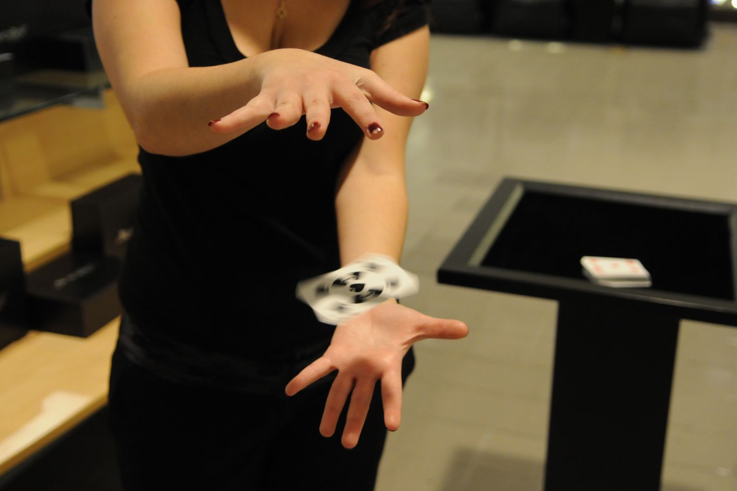 Woman performing magic to float and spin playing card
