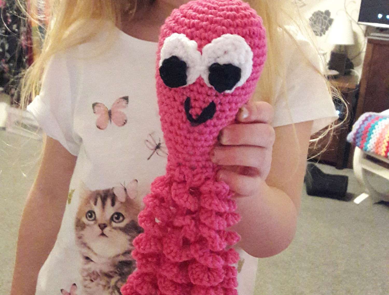 小女孩拿着一个粉红色的钩针章鱼