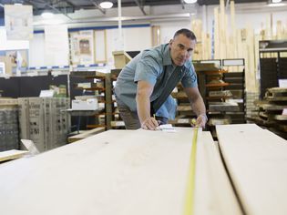 男人在家里测量木板条改善