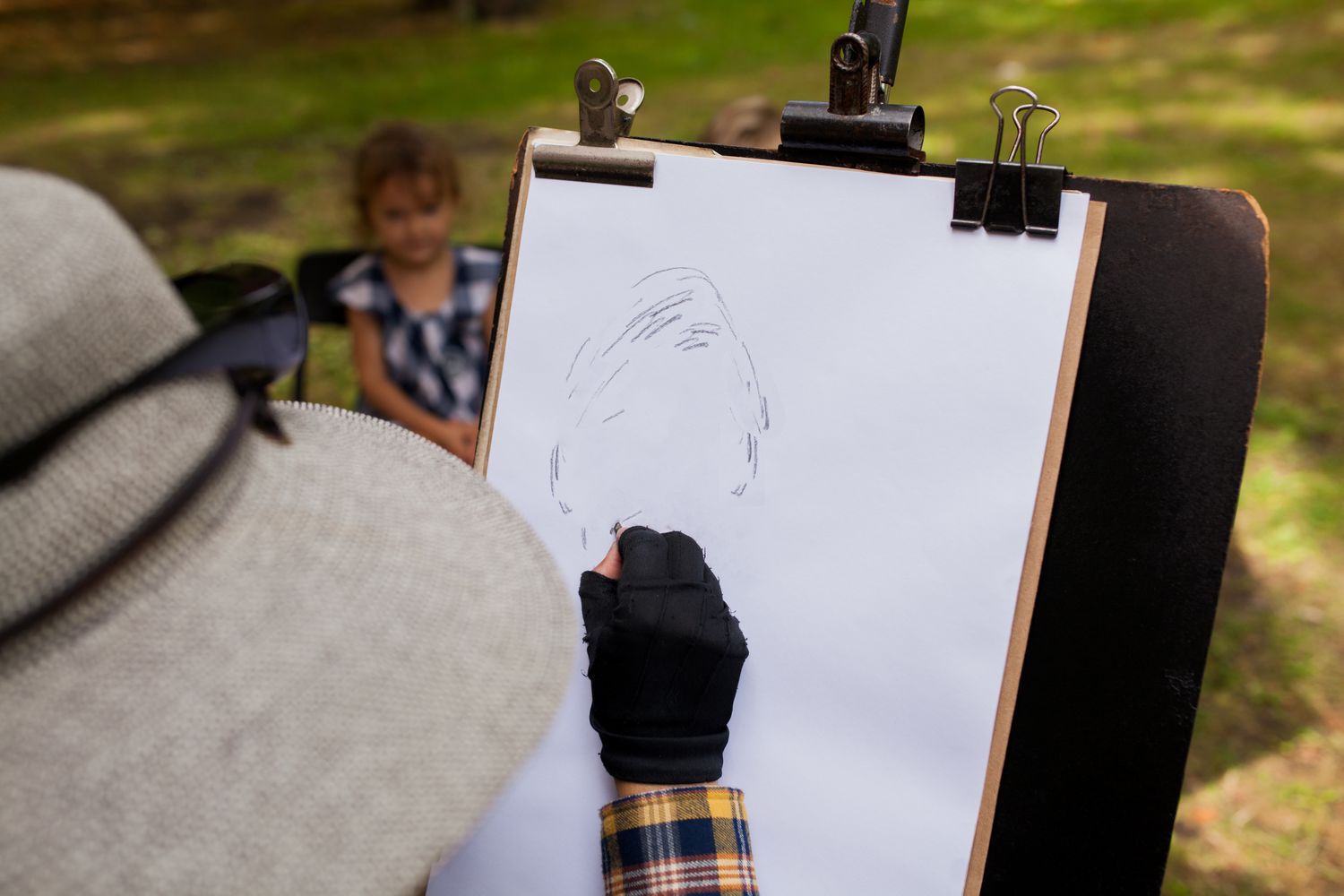 一位妇女正在为背景中的小女孩画素描