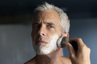 Mature man lathering face before shaving