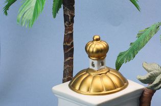 Scale miniature palm tree set behind a porcelain building in a Christmas Nativity set.