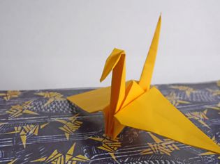 黄色的纸鹤坐在桌子上。