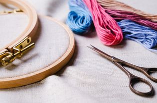 Embroidery set. White linen fabric, embroidery hoop, colorful threads and needls. Copy space