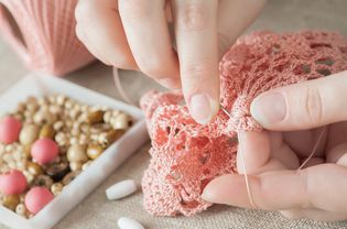 Female hands with pink knitting