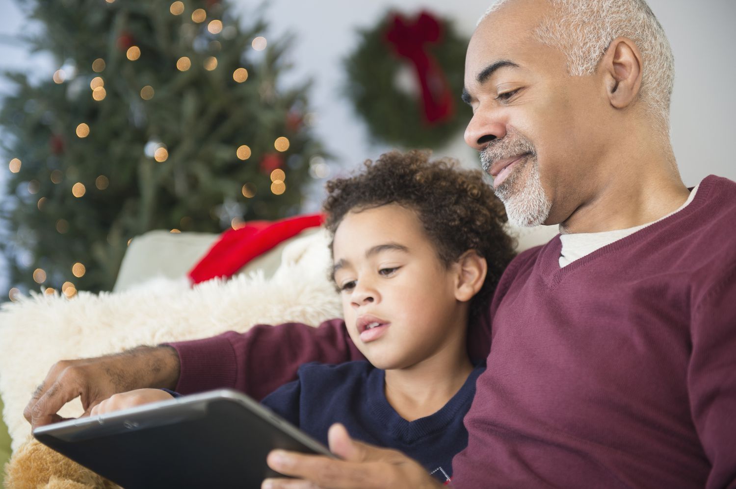 混血儿爷爷和孙子在圣诞节使用数码平板电脑