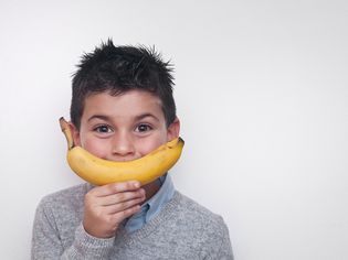 快乐的男孩拿着一根香蕉