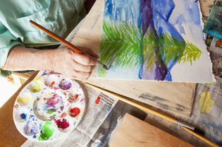 Caucasian artist painting watercolor tree