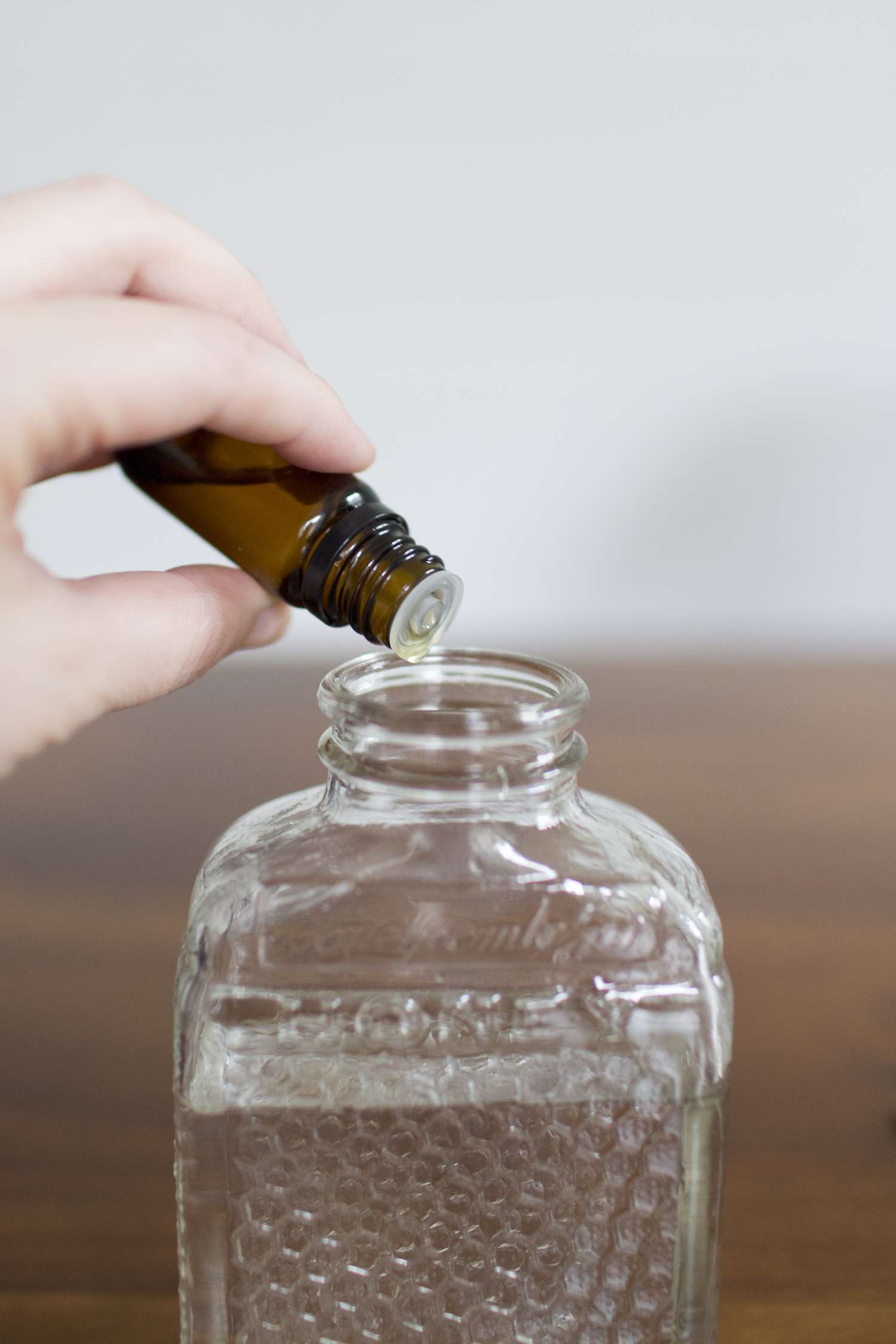 Adding essential oils to the diffuser bottle.