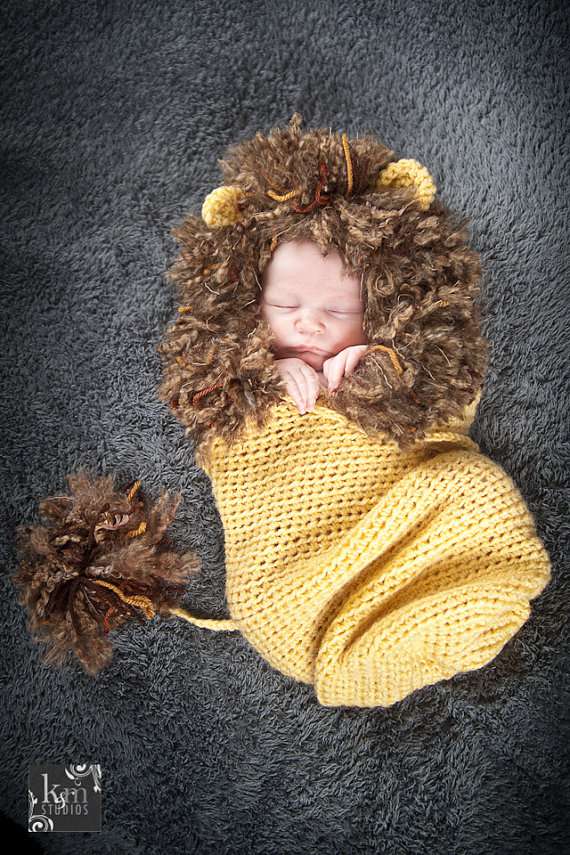 婴儿裹着狮子茧躺在地毯上