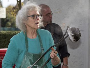 玛丽Cargile工作她Obvara锅在乐烧陶器开火埃尔卡米诺基本高中,萨克拉门托,加利福尼亚州,2014年11月6日。