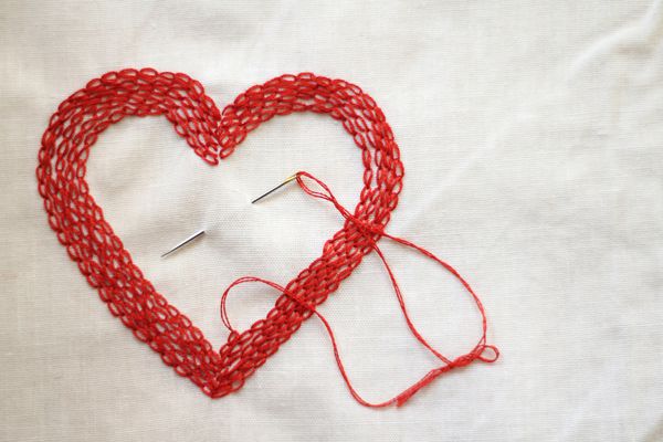 Red love heart made with needle and thread
