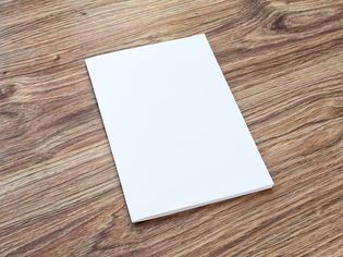 空白的小册子是一个木制的桌子上。