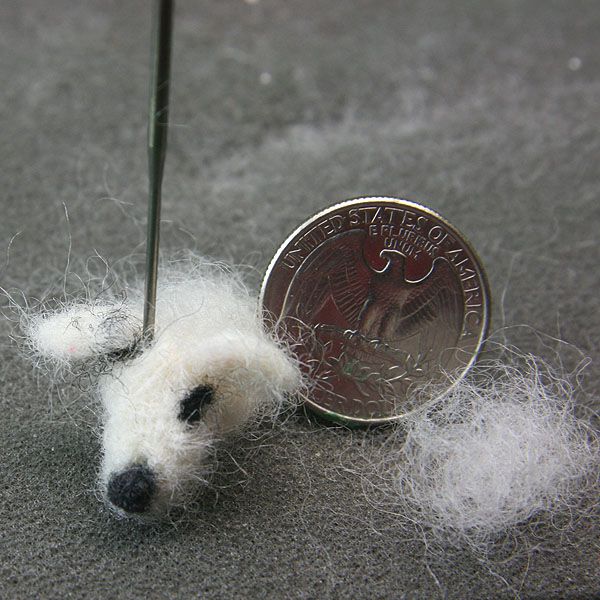 Felted ears and markings attached to a dollhouse miniature felted dog's head.